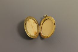 A large oval gold set memoriam locket, probably 14ct,