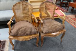A pair of carved walnut bergere back armchairs
