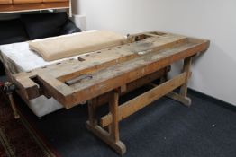 A mid 20th century heavy pine work bench fitted with two vice