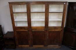 An early twentieth century pine triple door kitchen cabinet fitted with cupboards beneath