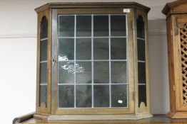 An oak leaded glass door wall cabinet