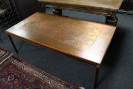 A large rosewood and copper topped coffee table depicting a map of the world