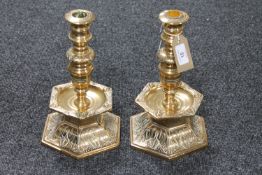 A pair of heavy brass candelabra on hexagonal bases,