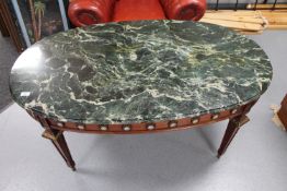 An oval French style marble topped coffee table with ormolu mounts