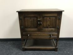 A Chapmans Siesta oak double door linen fold cabinet fitted with a drawer