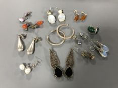 Twelve pairs of silver earrings.