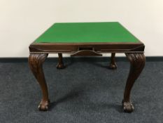A mahogany baize top card table on claw and ball feet