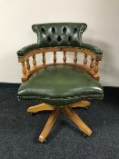 A green buttoned leather chesterfield swivel captain's chair
