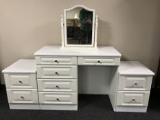 A white knee hole dressing with mirror and a pair of bedside stands