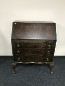 A mahogany serpentine fronted bureau on paw feet