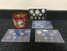 A tin containing pre decimal currency together with four cased coin sets