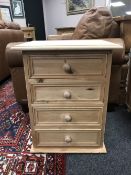 A pine four drawer bedside chest,