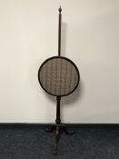 A mahogany pole screen on tripod support