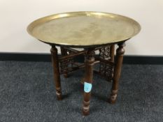 A folding brass topped table