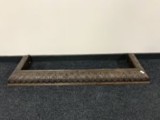 An early 20th century heavily carved oak fire curb