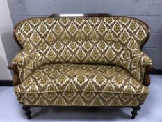 An early 20th century walnut framed settee in gold brocade,