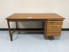 A late 20th century teak single pedestal desk