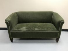 A 20th century two seater settee in green dralon
