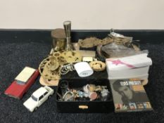 A tray containing ornate clock pendulum, assorted metalware, die cast cars,