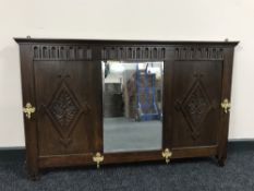 An early 20th century oak mirrored coat rack