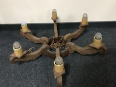 A carved oak six branch light fitting