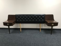 A late 20th century teak black vinyl continental headboard