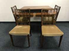 A mid 20th century extending table with three leaves and four chairs