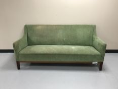 A mahogany framed settee upholstered in green