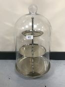A three tier cake stand under and glass dome