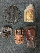 A tray of three Eastern carved wall masks, carved Eastern plaque,