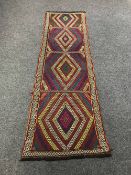 A Kilim runner on red ground