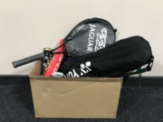 A box containing assorted badminton and tennis rackets,