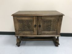 A 1920's carved oak double door cabinet