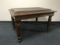 An early 20th century oak pull out table with two leaves