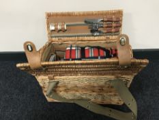 A wicker picnic hamper with contents