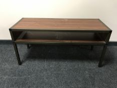 A rosewood two tier metal framed coffee table