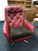 A 1960's red vinyl swivel armchair on chrome base