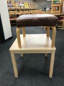 A contemporary beech effect coffee table together with a leather upholstered stool