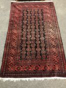 A fringed Persian rug on red ground