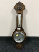 An oak cased barometer with silvered dial.