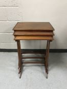 A nest of three mahogany tables on tapered legs with understretchers