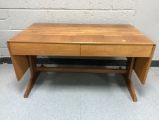 A late 20th century teak flap-sided coffee table fitted two drawers