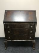 A mahogany serpentine fronted bureau on paw feet
