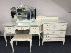 A four piece cream and gilt bedroom suite comprising of kidney shaped dressing table with stool,