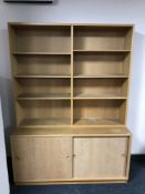 A late 20th century set of teak shelves with cupboard below
