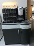 A Flavia coin operated coffee machine and fifteen drawer coffee sachet chest on a counter