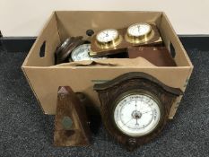 A box containing wooden barometers, metronome, miniature longcase clock,