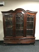 A reproduction mahogany triple door display cabinet