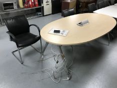 An oval office table with power points and two chrome office armchairs