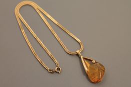A 9ct gold mounted amber and diamond set pendant on chain